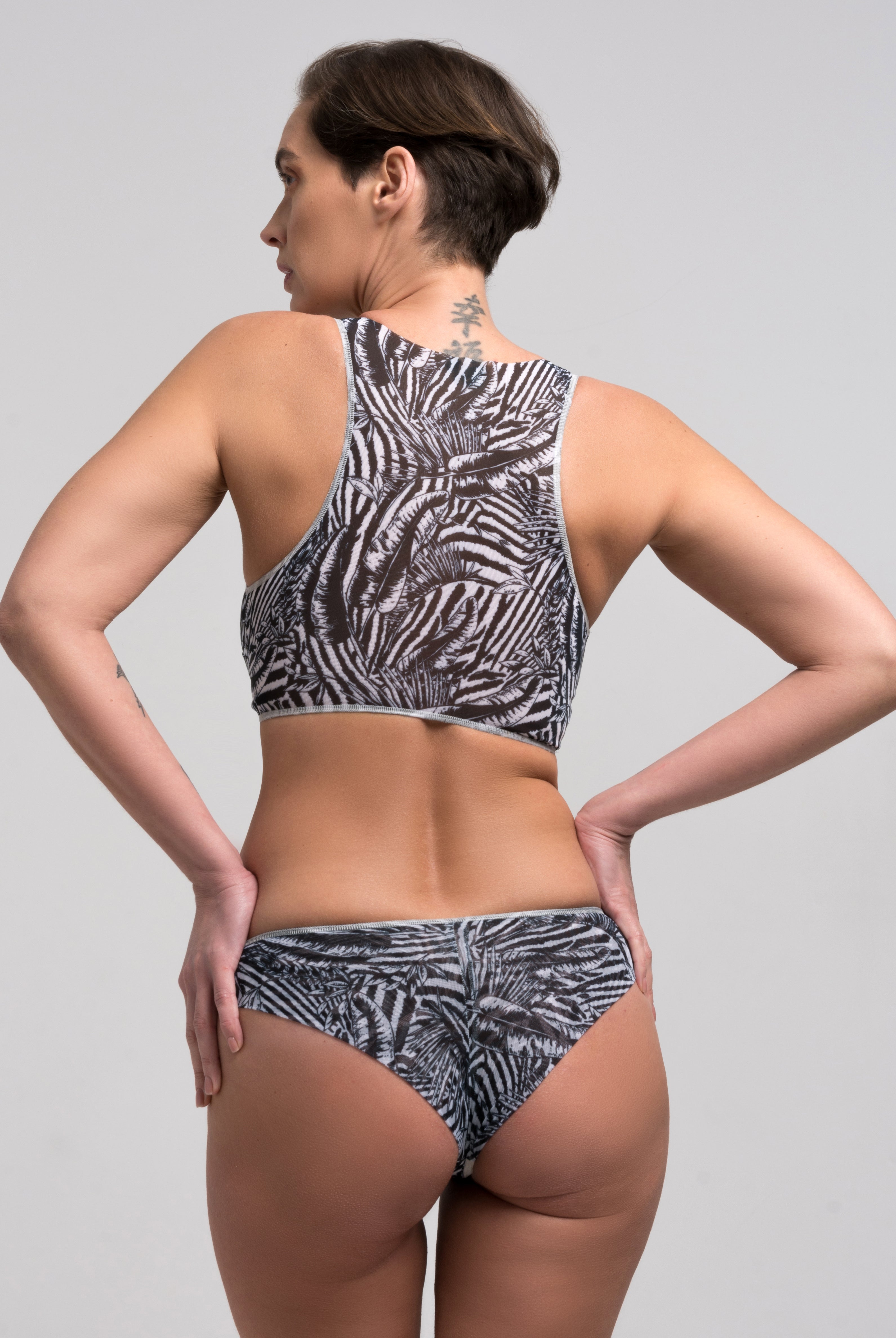 This file features sustainable tan-through smart swimsuits adorned with a trendy Fake Zebra print. Included is a stylish Brazilian bikini offering SPF35 protection, representing a new classic beachwear style