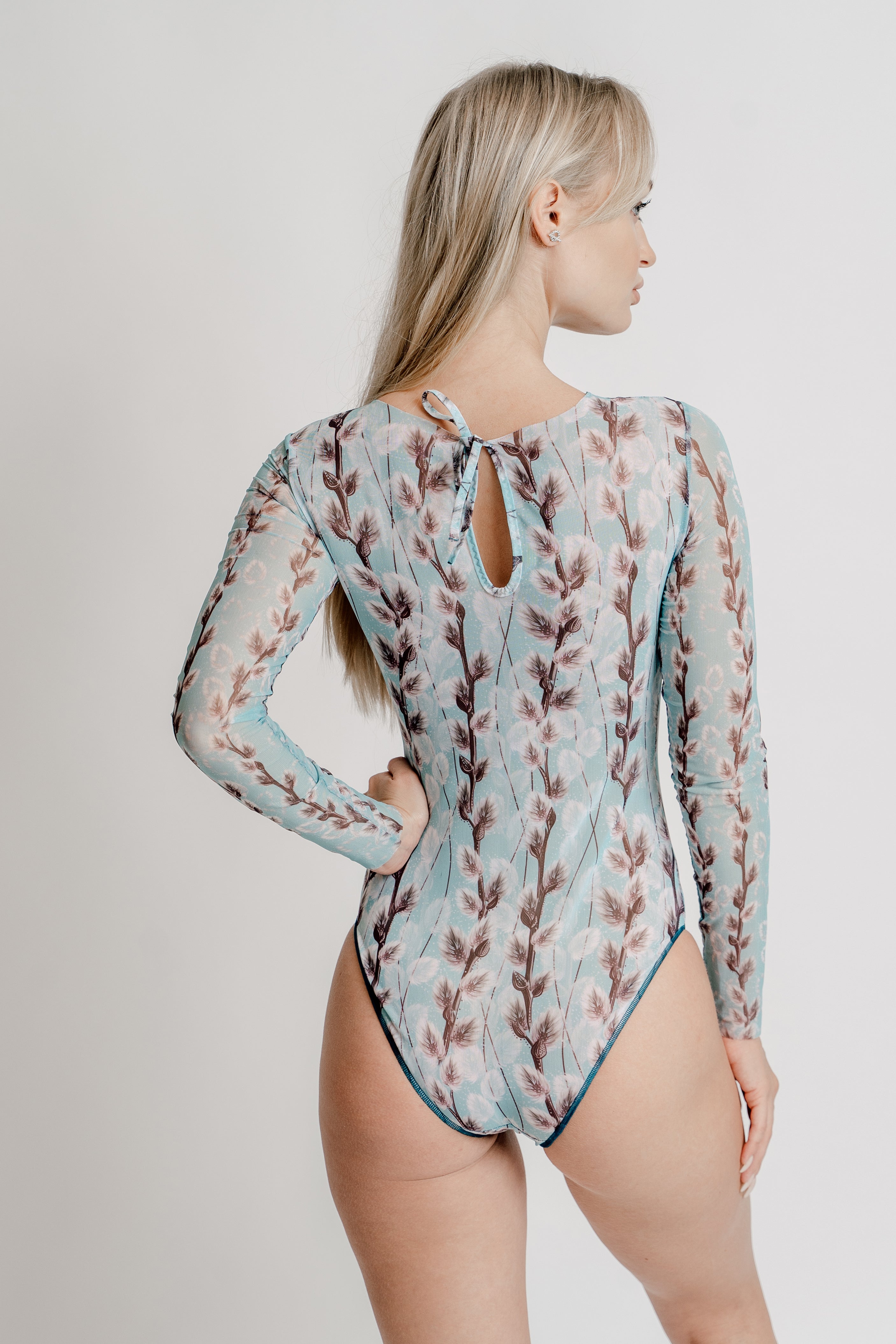 Explore our collection of tan-through swimsuits in the elegant Willow print. With sleeves for extra coverage, these sustainable pieces are now on sale. Experience classic luxury with a modern twist.